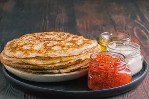 блинчики-с-красными-сметаной-и-медом-икры-на-черной-доске-русская-177369404.webp